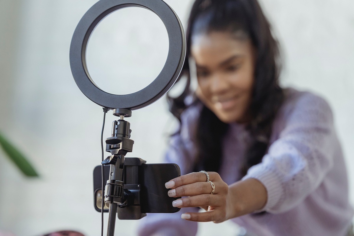 mulher usando um celular e uma ring light