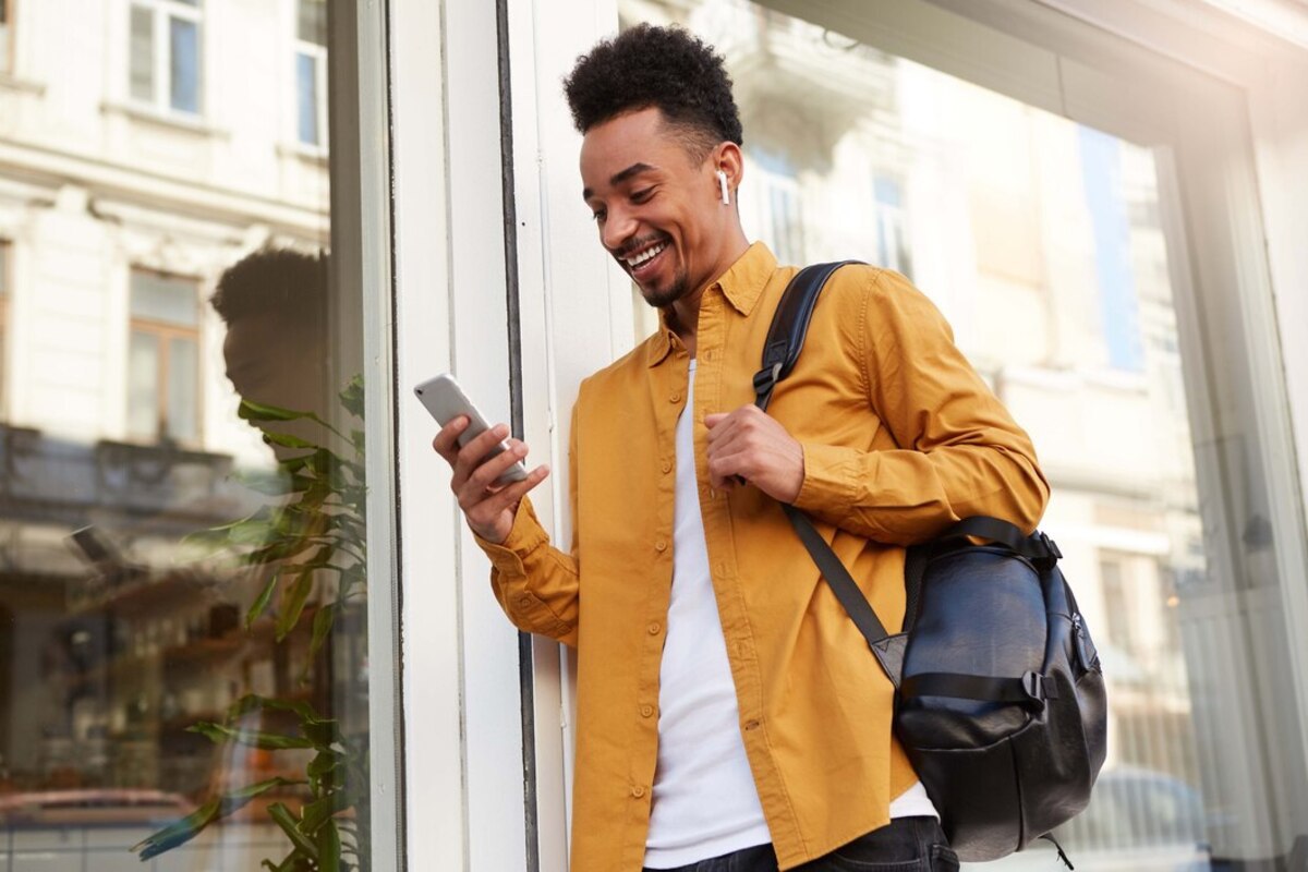 homem andando com o celular na mão