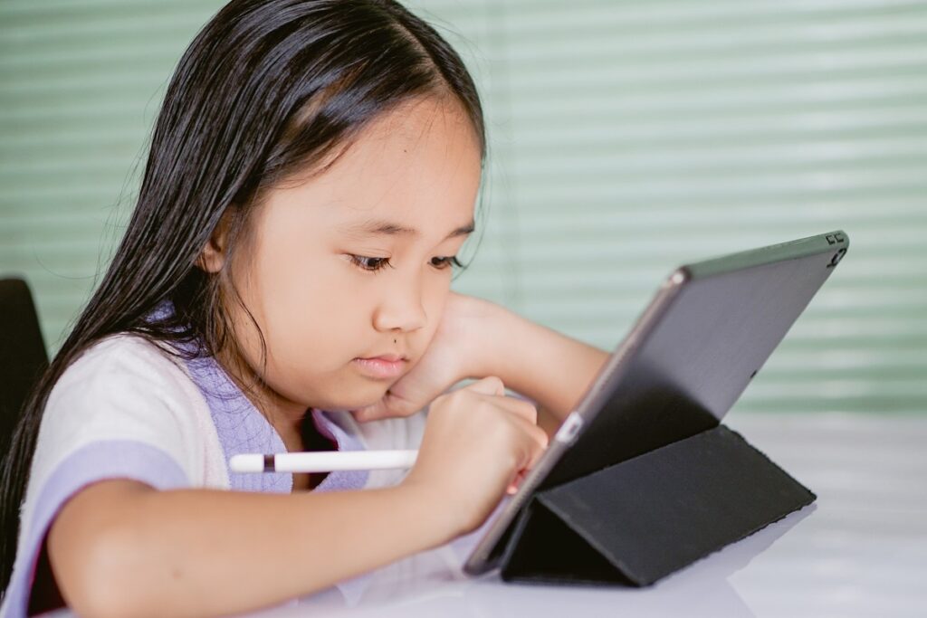 educação: a imagem mostra uma menina usando um tablet para estudar 