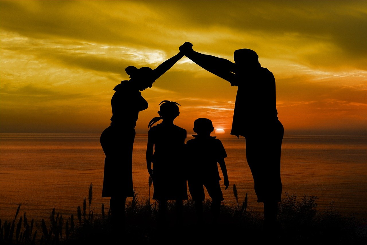 Família reunida diante de por do sol de mãos dadas aproveitando a paisagem em união proporcionada pela Tecnologia social