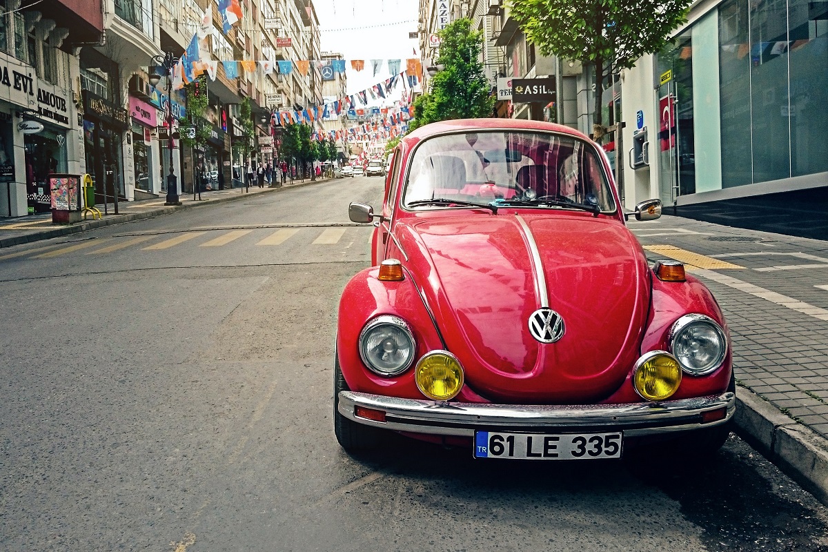 Fusca vermelho de frente estacionado em avenida como representação de Tecnologias antigas, já que usava motor que não precisava de água para refrigeração