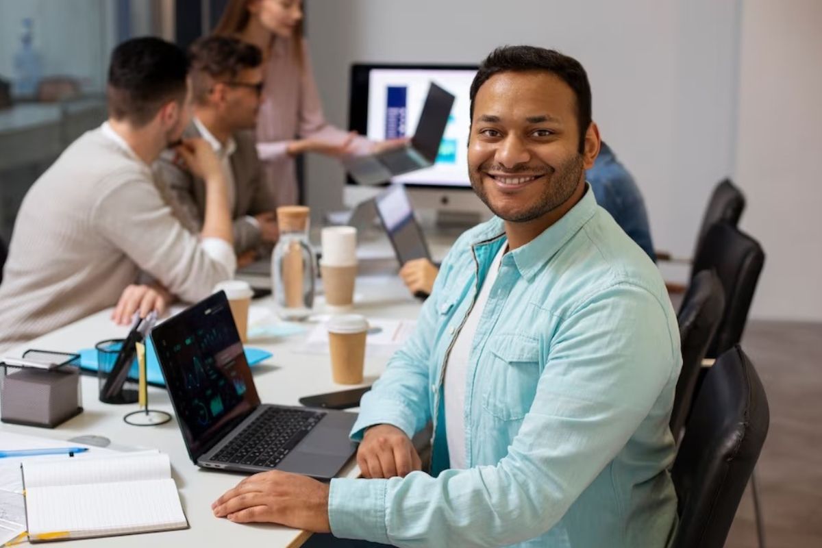 homem sentado em mesa de escritório, sorrindo