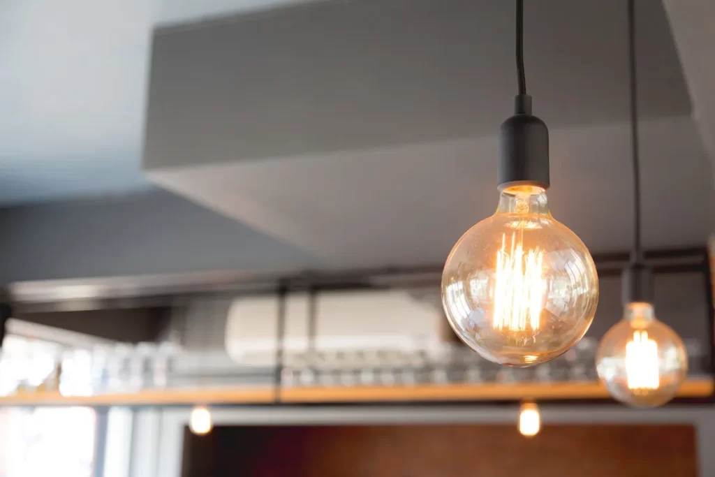 Lâmpadas pendentes com design industrial em um ambiente interno, destacando eficiência energética e estética moderna.